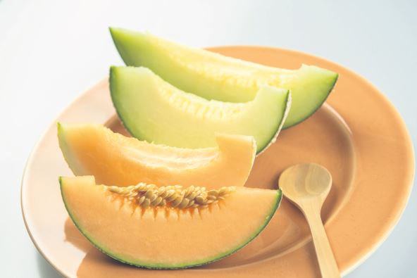 dinja--stockphotohoneydewmelonandjapanesemelonslicefreshripeorangeandsweetgreenslicelayonleafin2445299175.jpg