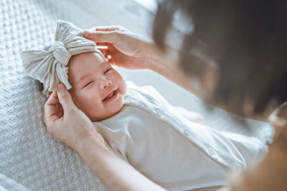 nadimci----stockphotohappyexcitednewbornbabylaughingatmomfacepositiveemotionsmotherwearingribbonheadband2478097063.jpg