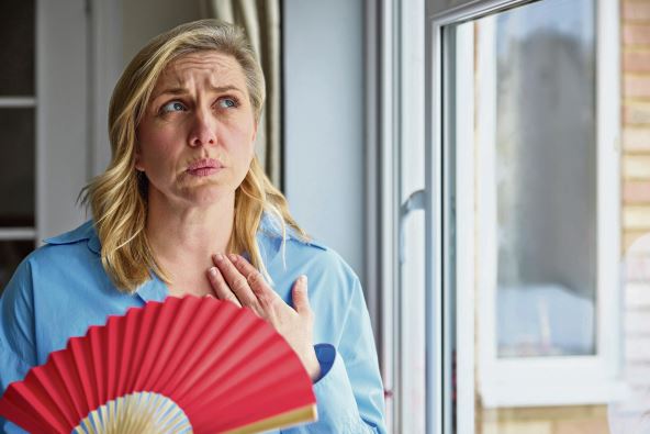 pijte-je-ako-ste-u-menopauzi---stockphotomenopausalmaturewomanhavinghotflushathomecoolingherselfwithhandheldpaperfan2281774409.jpg