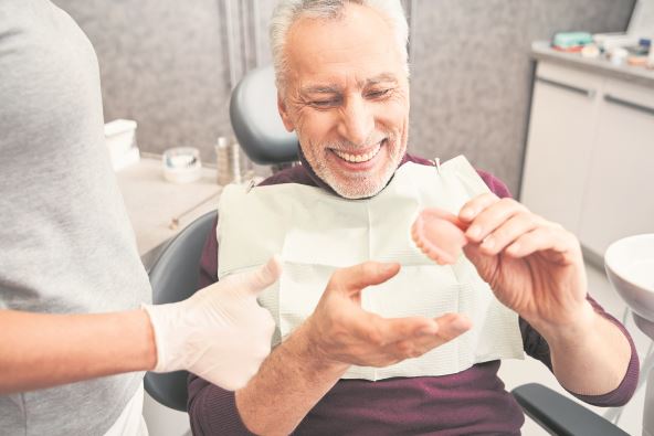 sledite-ove-savete---stockphotomynewteethcroppedviewofthedentistshowingtoseniorgreyhairedpatientteethdentures1926743942.jpg