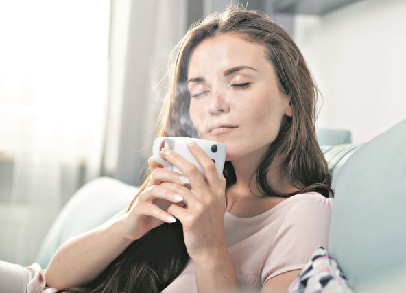 kako-ublaziti-simptome---stockphotoyoungwomansittingoncouchathomeanddrinkingcoffeecasualstyleindoorshoot436774867.jpg