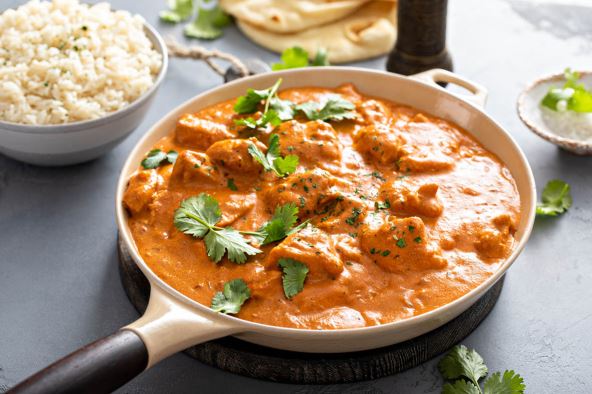 stock-photo-chicken-tikka-masala-cooked-marinated-chicken-chunks-in-spiced-curry-sauce-served-with-rice-and-2132788049.jpg