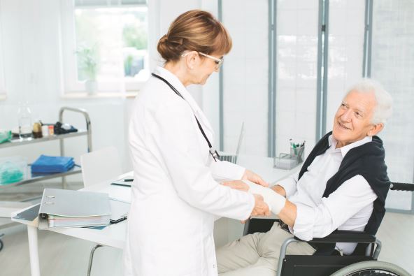 stock-photo-smiling-elderly-patient-grateful-for-help-of-a-doctor-in-white-uniform-fixing-his-hand-768825655.jpg