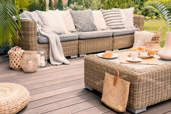 stock-photo-wicker-patio-set-with-beige-cushions-standing-on-a-wooden-board-deck-breakfast-on-a-table-on-a-1170474232.jpg