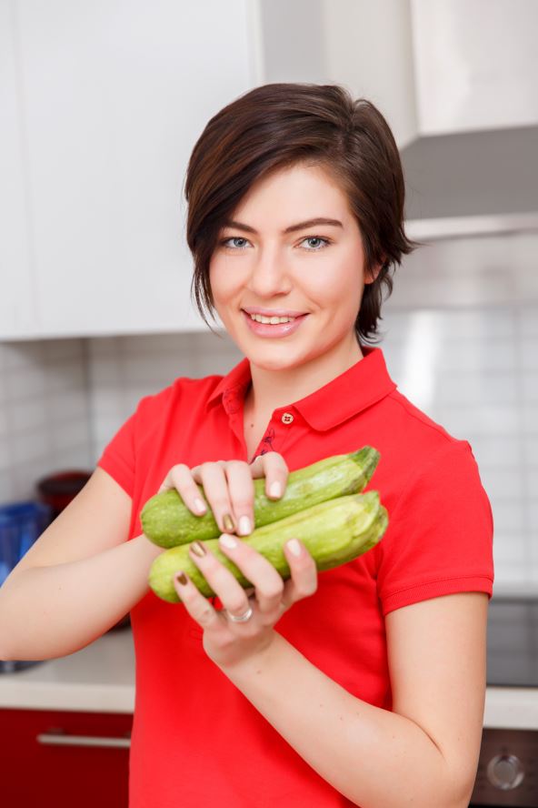 PODSTICU RAD CREVA I SMIRUJU ZIVCE    stock-photo-girl-with-zucchini-in-kitchen-580194280.jpg