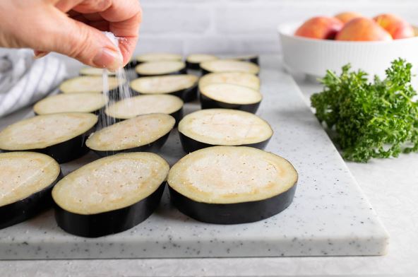 NE TREBA GA UVEK SOLITI PRE KUVANJA  stock-photo-woman-s-hand-sprinkles-salt-over-sliced-eggplant-on-a-cutting-board-in-the-kitchen-2294919375.jpg