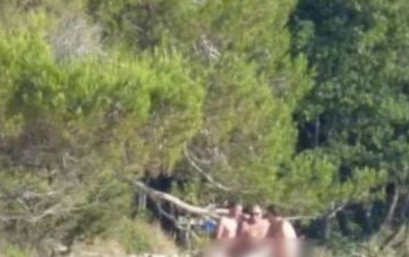 Troje golih ljudi na plaži