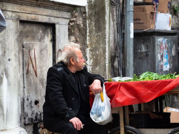 Stariji čovek prodaje na pijaci