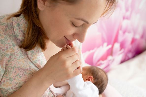 Majka uživa pored novorođene bebe