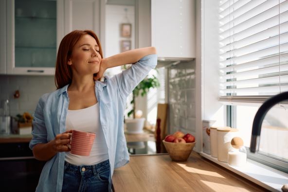 Žena ujutru uživa u ispijanju kafe