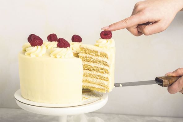 2    stock-photo-a-piece-of-white-cake-with-cream-and-raspberry-in-a-woman-s-hand-on-a-metal-spatula-grey-1657101130.jpg