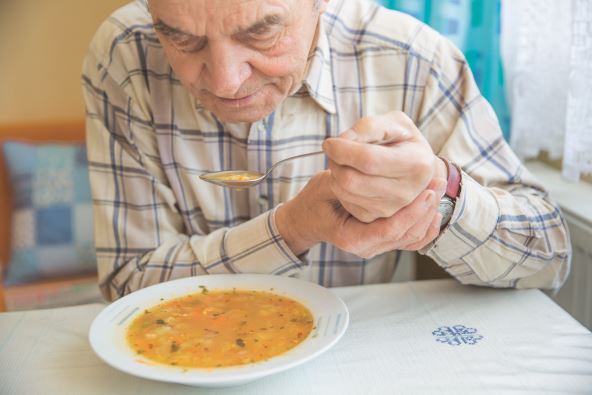 stock-photo-elderly-man-with-parkinsons-disease-holds-spoon-in-both-hands-1623098284.jpg