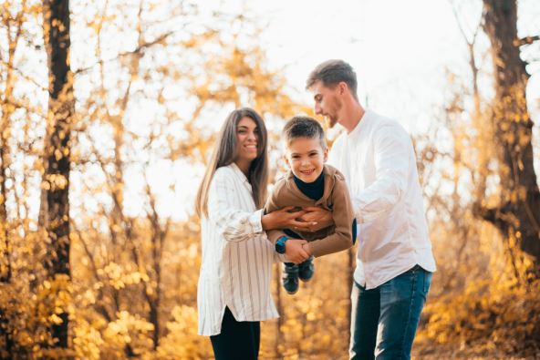 Porodica se igra u parku sa detetom u jesen