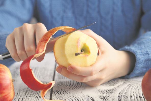 stock-photo-girl-peeling-an-apple-on-table-571835503.jpg