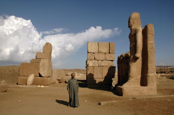 edan Egipćanin stoji pored monumentalne kapije Šošenka III kod drevnog hramskog kompleksa Tanis u istočnoj delti reke Nil u Gornjem Egiptu