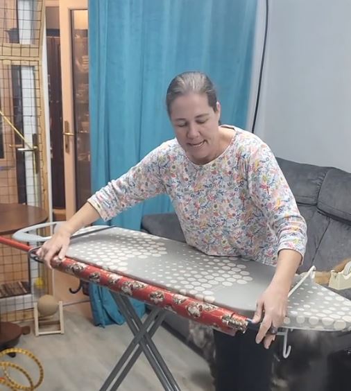 Kler Li pričvršćuje vešalice za dasku za peglanje