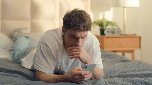 Muškarac čita sadržaj na telefonu