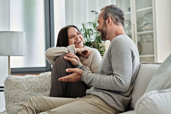 VAZAN JE NACIN NA KOJI RAZGOVARATE   stock-photo-joyful-child-free-couple-talking-on-couch-in-modern-living-room-quality-time-at-cozy-home-2402592991.jpg