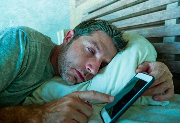 NEPOTREBNO BUDJENJE USRED NOCI  stock-photo-lifestyle-indoors-portrait-of-young-internet-addict-man-sleeping-on-home-couch-holding-mobile-phone-1167193591.jpg
