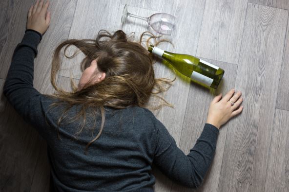 Žena leži na podu onesvešćena od alkohola