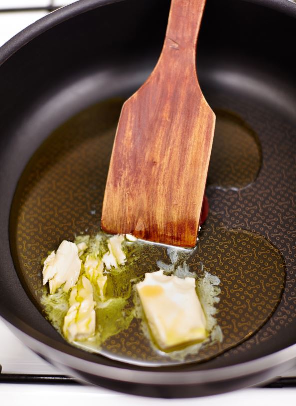 stock-photo-butter-melting-in-a-hot-pan-with-a-wooden-spoon-174772847.jpg