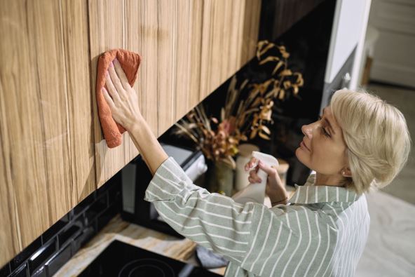 KUHINJSKA POSLA   stock-photo-middle-aged-caucasian-woman-cleaning-wooden-kitchen-cabinet-with-cloth-and-spray-bottle-standing-2705619921 (1).jpg