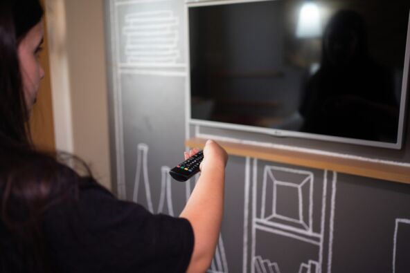 Žena sa daljincem gasi TV.jpg