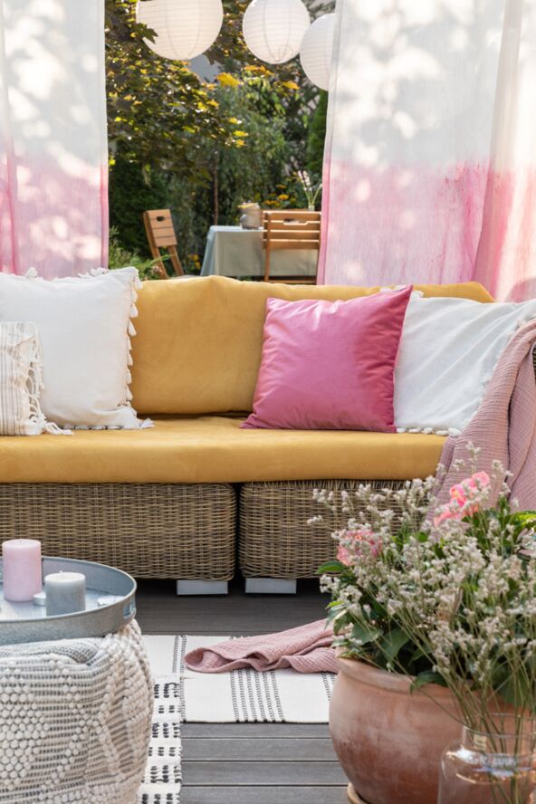 JASTUCI I SEDALICE stock-photo-flowers-and-candles-in-front-of-rattan-sofa-with-colorful-pillows-on-the-terrace-with-drapes-real-1404505973.jpg