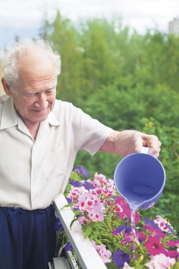 stock-photo-smiling-senior-man-watering-the-flowers-on-his-balcony-129423728.jpg
