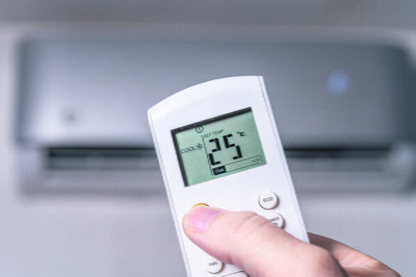 stock-photo-a-hand-holding-the-remote-control-of-the-air-condition-2334848115.jpg