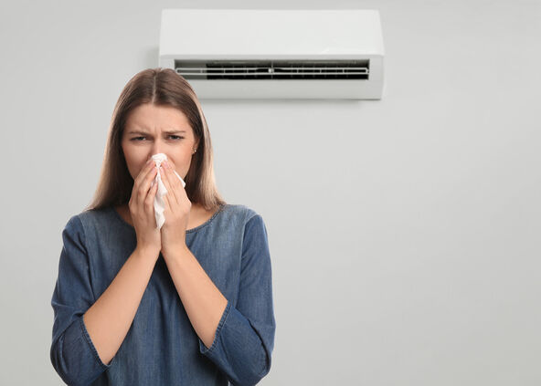 stock-photo-woman-suffering-from-cold-in-room-with-air-conditioner-on-white-wall-space-for-text-2216752317.jpg