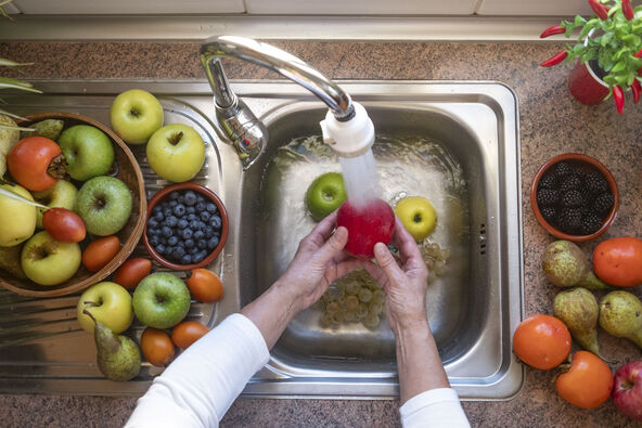 stock-photo-elderly-woman-washing-a-red-apple-on-a-sink-full-of-water-background-with-different-types-of-fresh-2648002751.jpg