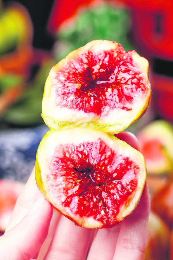 stock-photo-fresh-ripe-figs-cut-in-half-showing-vibrant-red-flesh-and-seeds-held-in-hand-with-colorful-fruit-2821836029.jpg