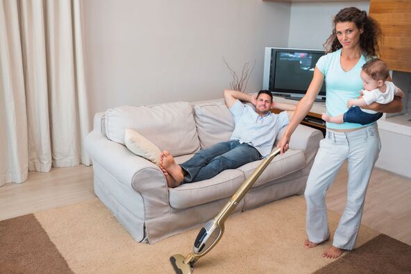 stock-photo-full-length-portrait-of-woman-cleaning-house-while-carrying-baby-with-man-relaxing-on-sofa-173980019.jpg