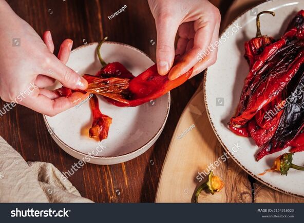 stock-photo-peeling-the-skin-of-red-peppers-as-ingredient-for-spread-called-ajvar-raw-and-fried-2154316523.jpg