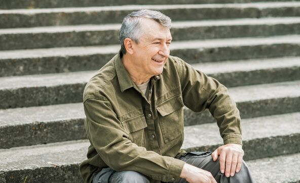 Stariji muškarac sedi na stepenicama