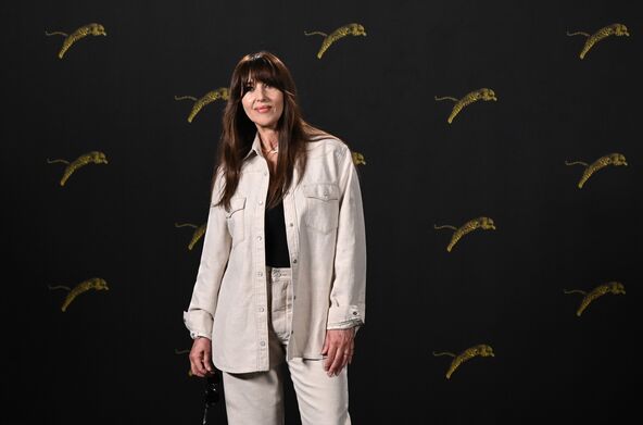 Monika Beluči u belim pantalonama i košulji