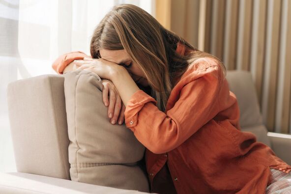 stock-photo-a-depressed-sick-woman-sits-sadly-leaning-her-face-on-the-back-of-the-sofa-2773745731.jpg