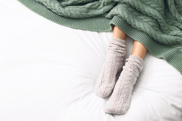 stock-photo-woman-wearing-warm-socks-in-comfortable-bed-above-view-space-for-text-2249757513.jpg