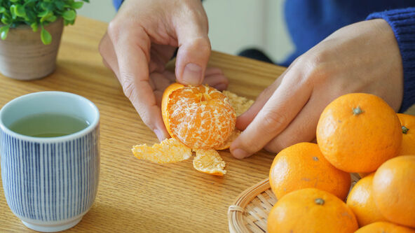 stock-photo-japanese-mandarin-oranges-satsuma-orange-a-man-peels-a-mandarin-orange-japanese-green-tea-and-2408116307.jpg