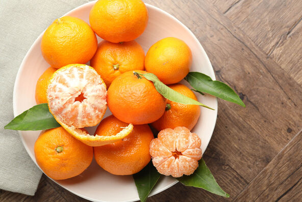stock-photo-fresh-tangerines-and-green-leaves-on-wooden-table-top-view-2720725731.jpg